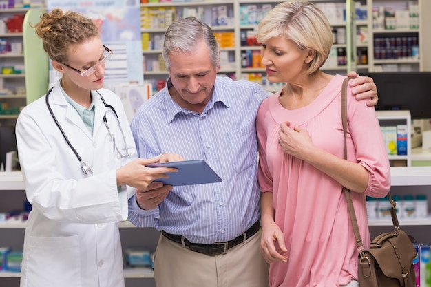 Farmacêutico mostrando tablet pc para clientes