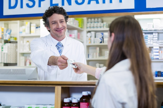 Foto farmacéutico que recibe el pago del cliente