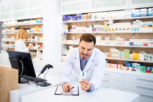 Farmacêutico que vende medicamentos em loja da farmácia.