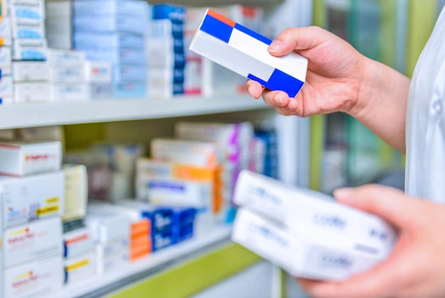 Foto farmacêutico segurando a caixa de remédios na farmácia