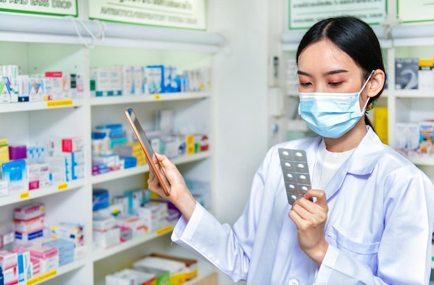 Farmacêutico segurando caixa de remédios e touch pad para barra de pesquisa em exibição na farmácia