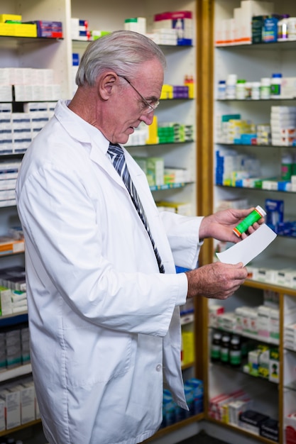 Farmacêutico segurando uma receita e medicamento