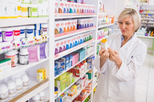 Farmacéutico sonriente que mira la medicina