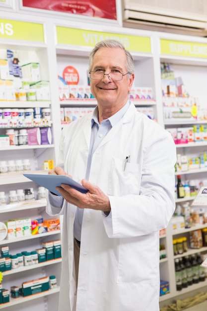 Farmacéutico sonriente que usa la PC de la tableta