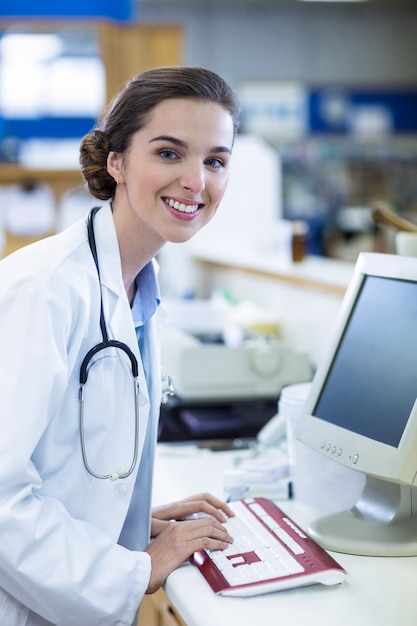 Farmacéutico trabajando en computadora en farmacia