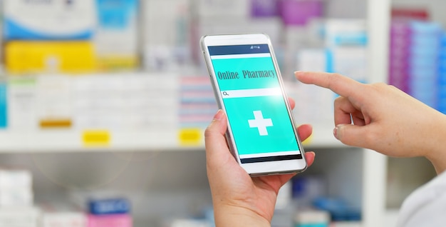 Farmacêutico usando smartphone móvel para barra de pesquisa em exibição nas prateleiras das drogarias de farmácias