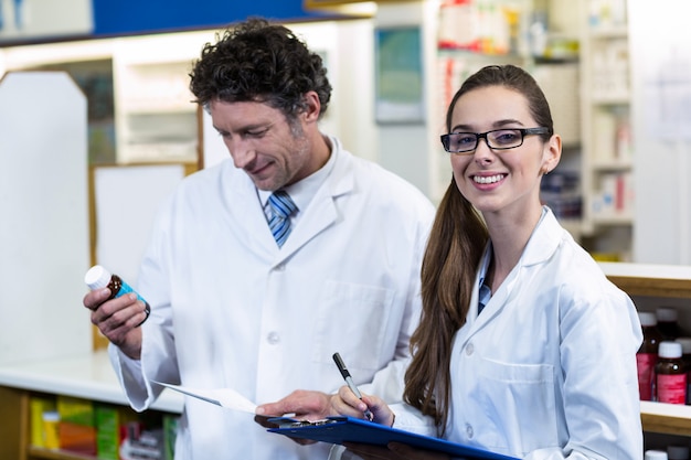 Farmacéuticos que controlan y escriben recetas de medicamentos