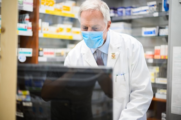 Farmacista trabajando con una computadora en su tienda