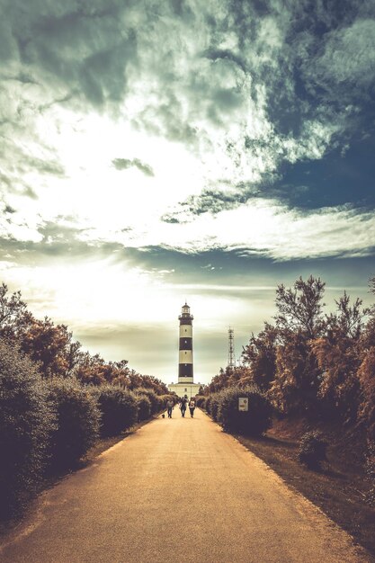 Foto faro por los árboles contra el cielo.