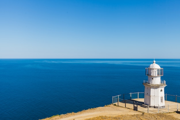 Faro blanco sobre un fondo de mar azul