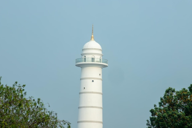 Un faro blanco con una tapa dorada.