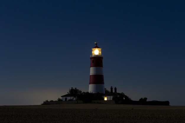 Faro bajo el cielo azul oscuro por la noche