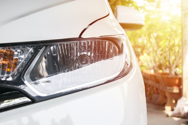 faro del coche de la ciudad con bengalas de la luz del sol