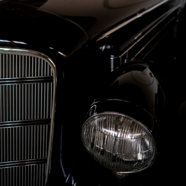 El faro de un coche negro antiguo, raro, vintage.