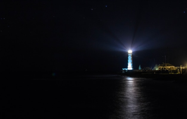 Faro en la costa del mar en la noche