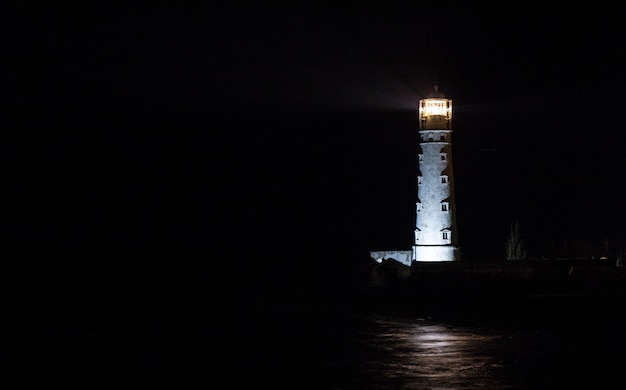 Faro en la costa del mar en la noche