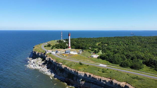 Un faro se encuentra en un acantilado con vista al océano.