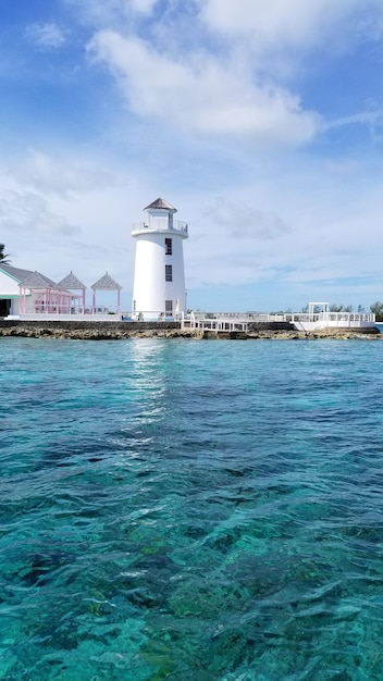 Foto faro por el mar contra el cielo azul