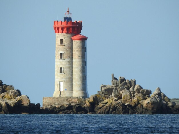 Foto faro en el mar contra el cielo azul