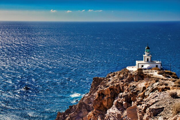 Foto faro por el mar contra el cielo