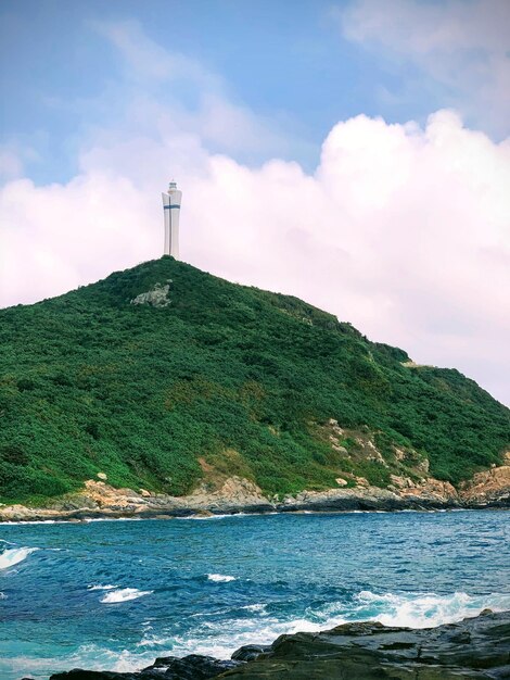 Foto faro por el mar contra el cielo