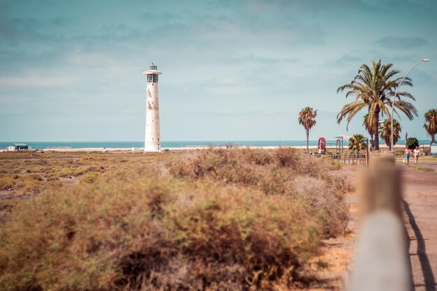 Foto faro por el mar contra el cielo