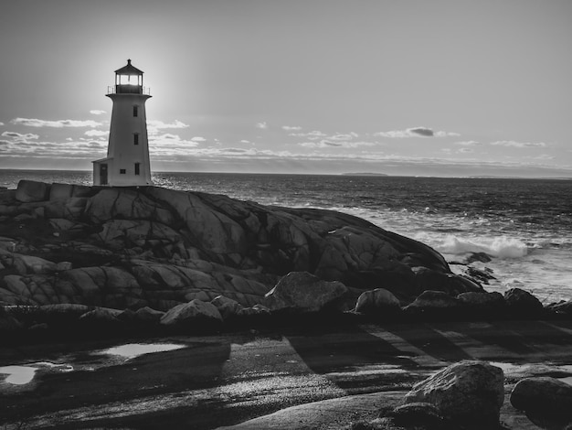 Foto faro por el mar contra el cielo