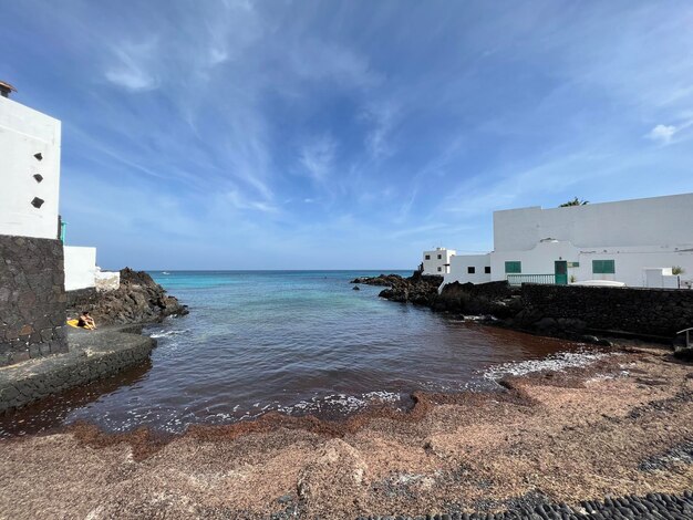 Foto faro por el mar contra el cielo