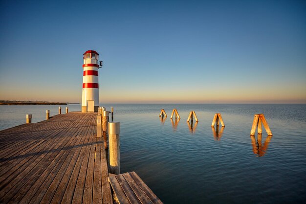 Foto faro en el muelle sobre el mar contra un cielo despejado