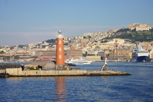 Faro de Nápoles con puerto deportivo y paisaje urbano Italia