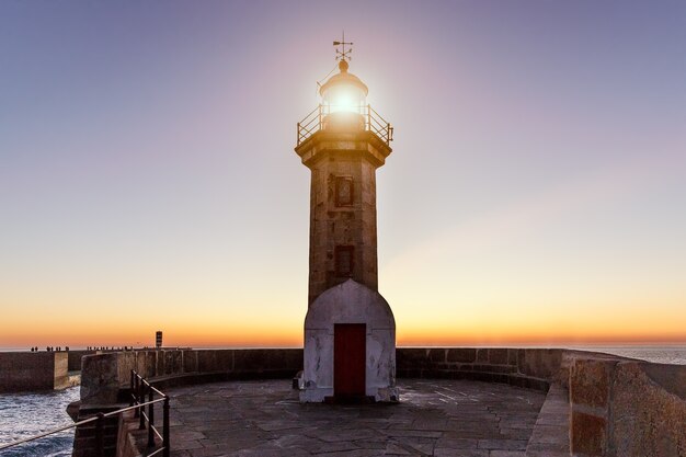 Faro en el océano al atardecer