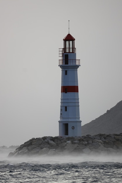 Faro entre las olas ascendentes de una tormenta en Lodos Turgutreis Bodrum