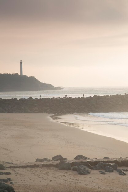 Faro y playa al anochecer, Biarritz, Francia