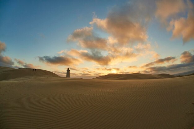 Faro en la playa al atardecer