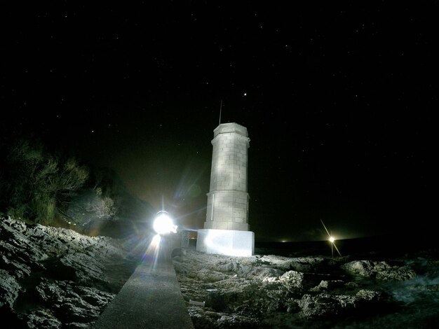 Faro en la playa contra el cielo por la noche