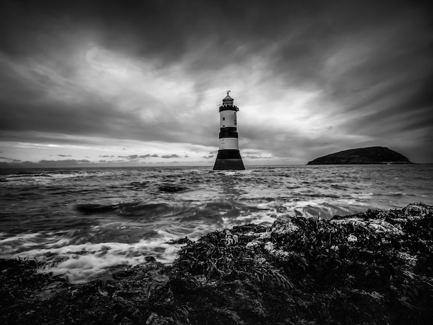 Foto faro en la playa contra el cielo nublado