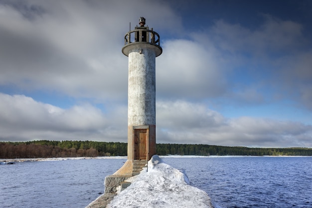 Un faro en tiempo soleado Faro en el rompeolas Faro en el lago