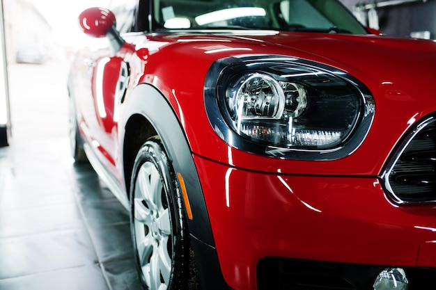 Faróis e capô de carro esporte vermelho na garagem