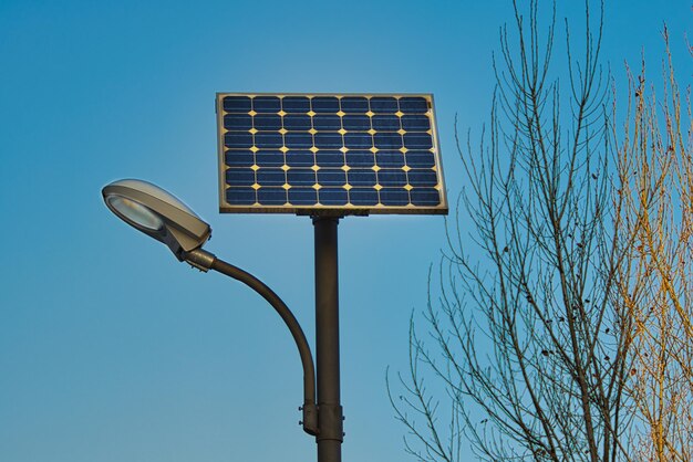 Farol alimentado por energía solar bajo un cielo azul