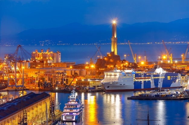 Farol antigo histórico Lanterna, terminais de contêineres e passageiros no porto de Gênova, no mar Mediterrâneo, à noite, Itália.