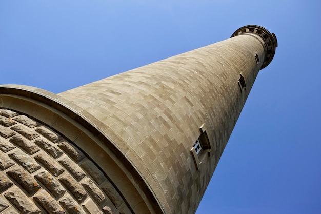 Farol apedrejado e céu azul