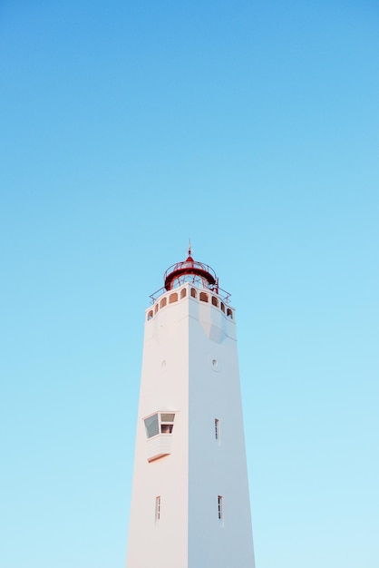 farol branco no fundo do céu azul perto do mar