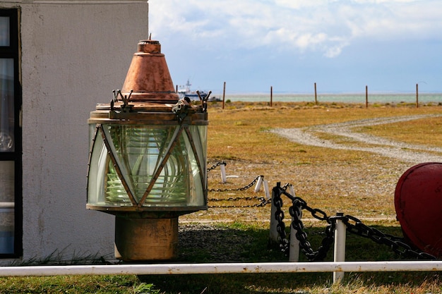 Farol de bronze náutico descansando no chão