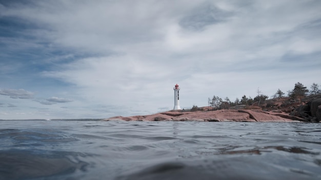 Farol de navegação marítima em uma capa de granito Vista da água