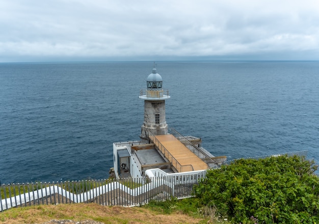 Farol de Santa Catalina de Lekeitio em uma manhã nublada de primavera, com o mar ao fundo, paisagens de Bizkaia