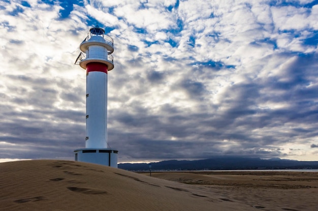 Farol na praia acima de um céu nublado