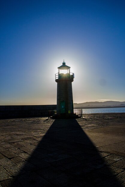 Foto farol pelo mar contra o céu