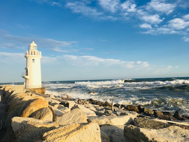 Farol pelo mar contra o céu