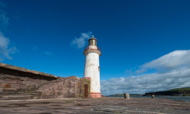 Farol por passarela contra o céu azul