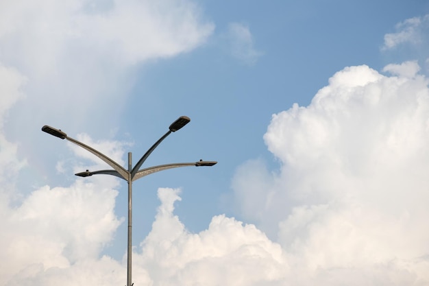 Una farola con un cielo azul y nubes en el fondo.